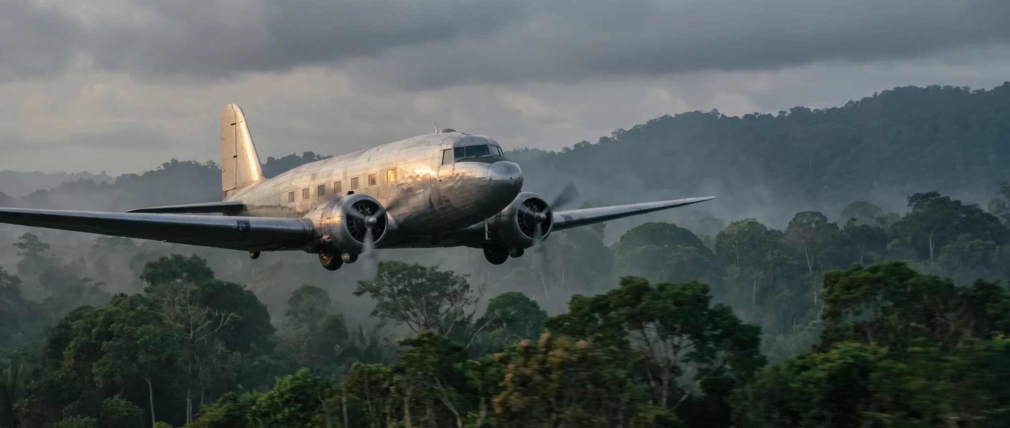 The DC-2 approaching over misty jungle under storm light