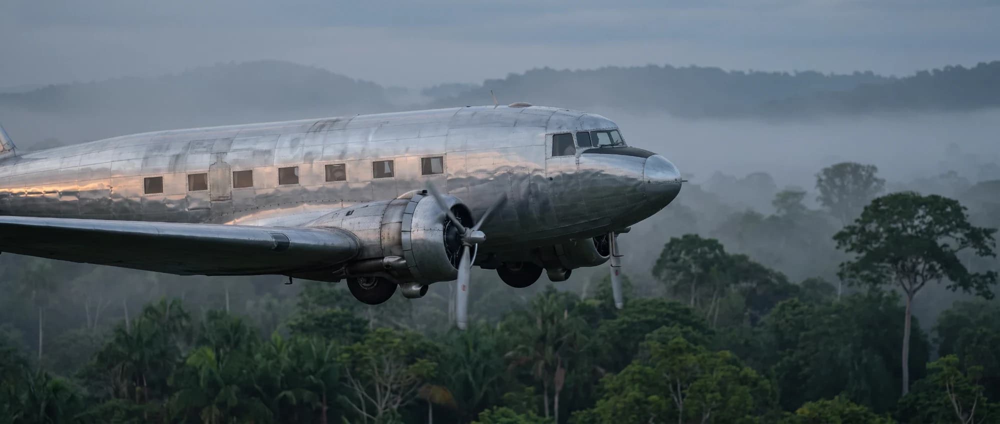 The DC-2 tracked side-on over the rainforest